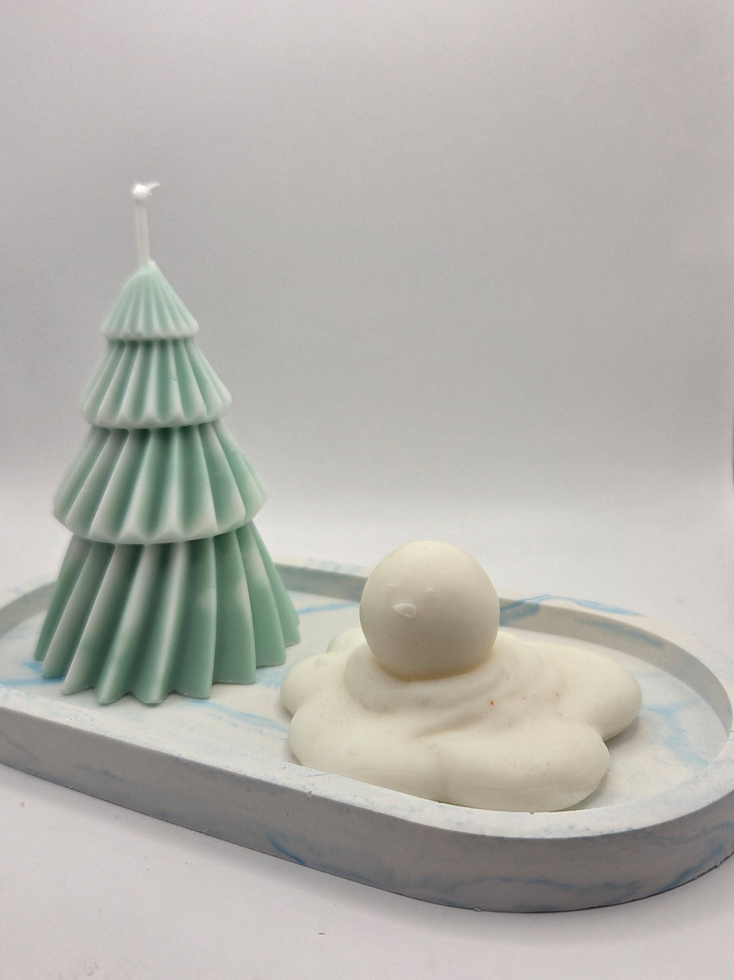 Kerstboom en gesmolten sneeuwman op een blauwe onderlegger